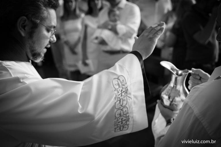 padre abençoando a água do batismo