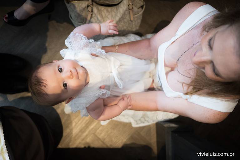 madrinha segurando sua afilhada de batismo no colo