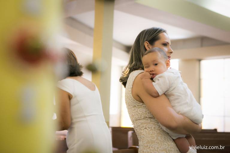 filho no colo da mãe no dia do batizado