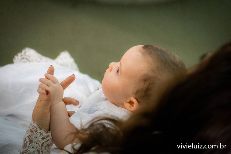 filha bebê segurando a mão da mãe