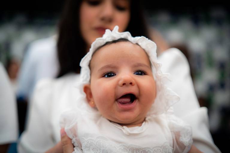 bebê de branco sorrindo