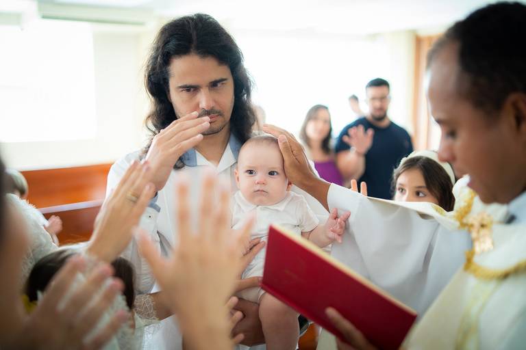padre abençoando o bebê recém batizado