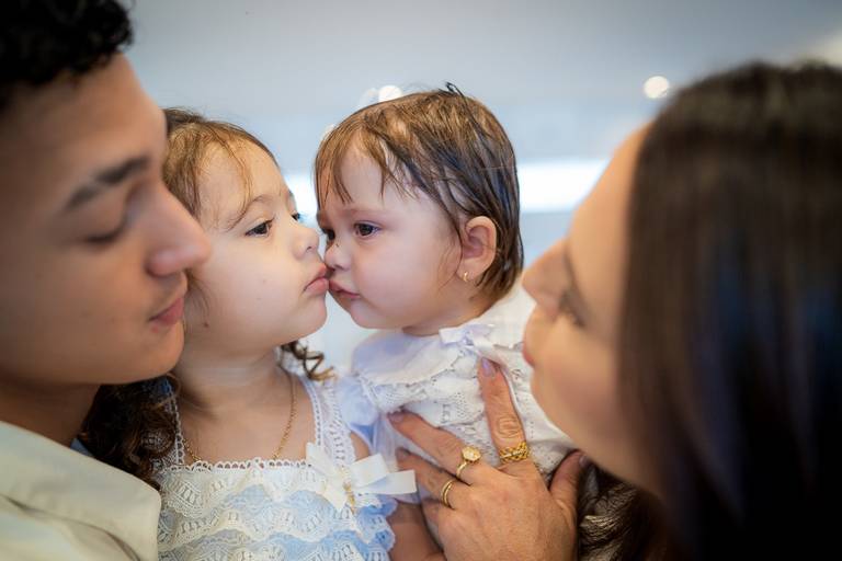 família abraçando a filha recém batizada