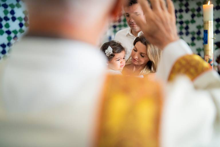 padre abençoando a família no dia do batizado