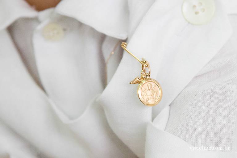 pingente de batismo na roupa do bebê