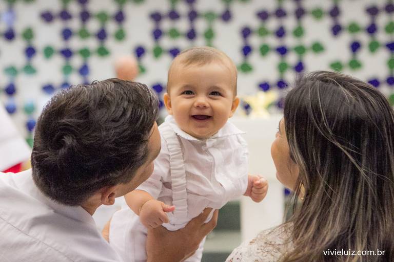 criança rindo no colo dos pais