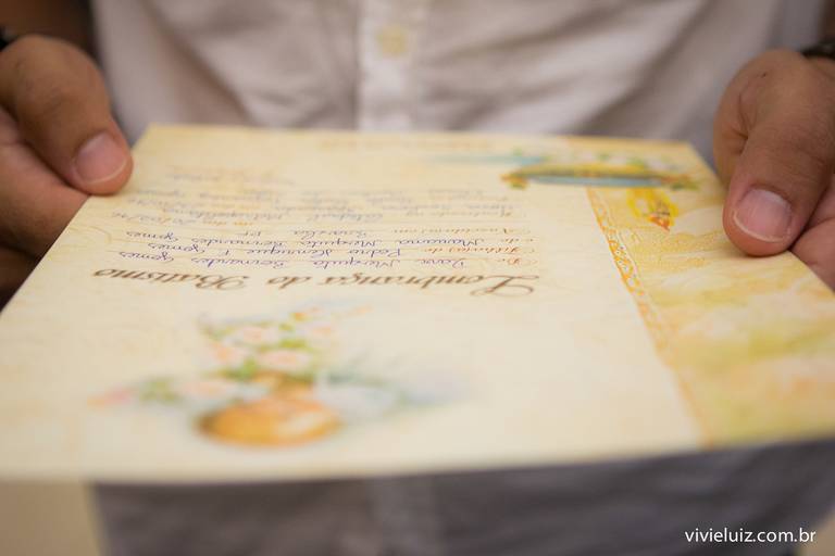 pai segurando o certificado de batismo do filho