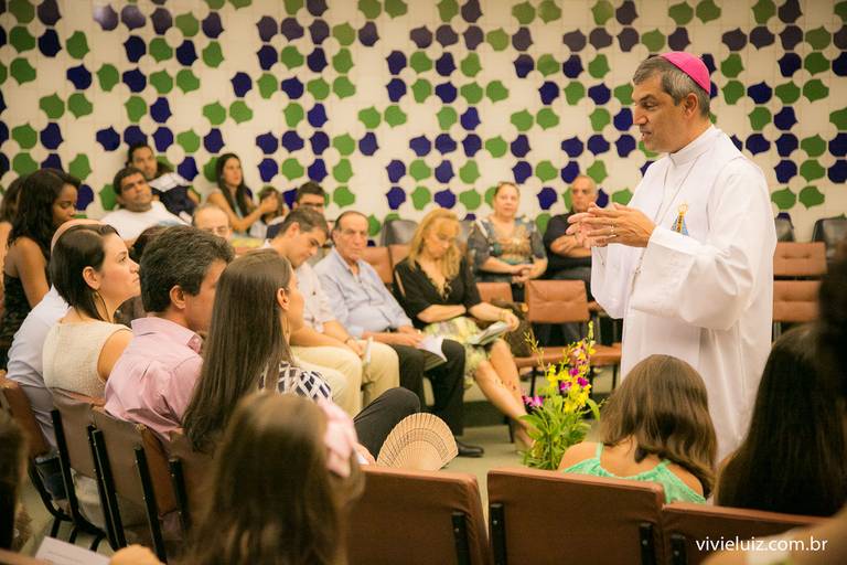 padre dando homilía para a família no batizado