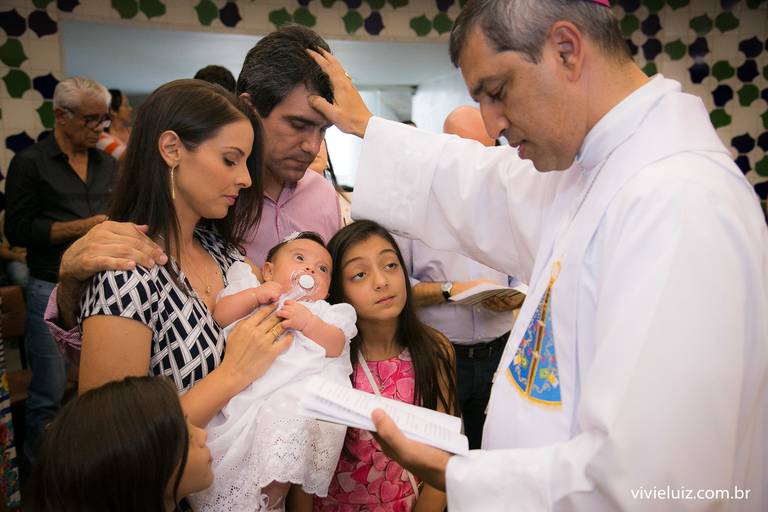 padre dando uma benção na família no batismo