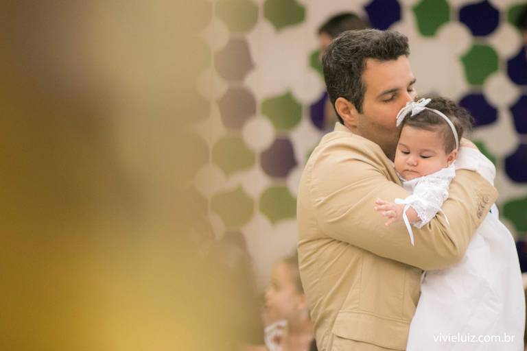 pai abraçando a sua filha que foi batizada