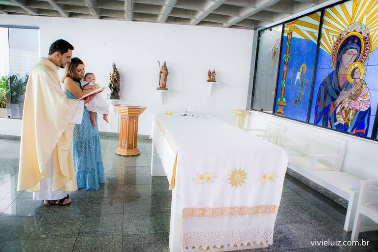 padre, mãe e filha, em frente ao altar da Igreja para o batizado
