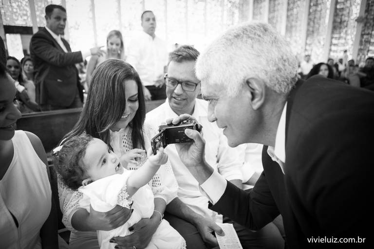avô granvando o neto em seu batizado