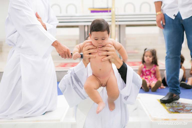 padre batizando o bebê na pia batismal
