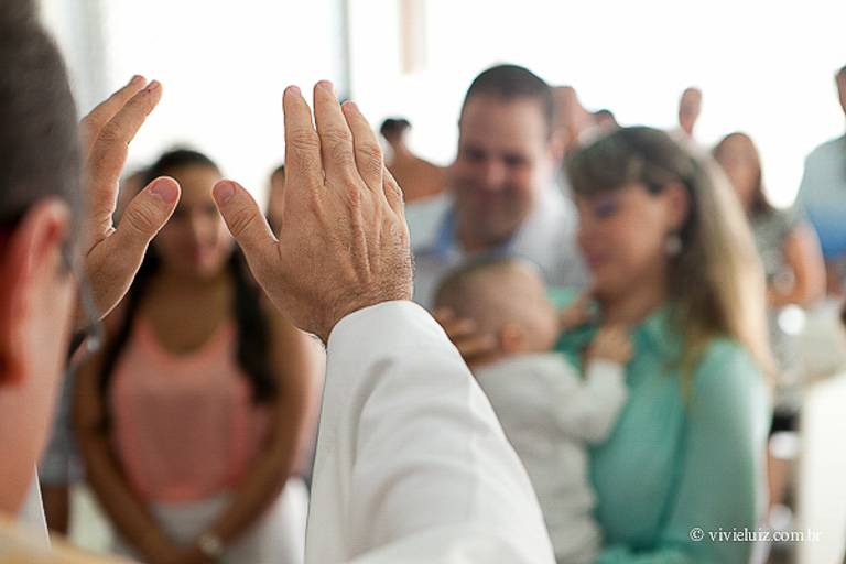 padre abençoando a família no dia do batizado
