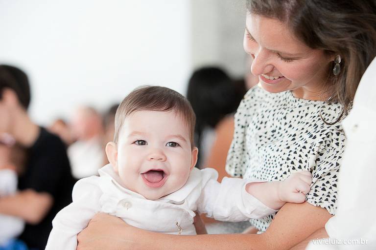 bebê sorrindo no colo da madrinha