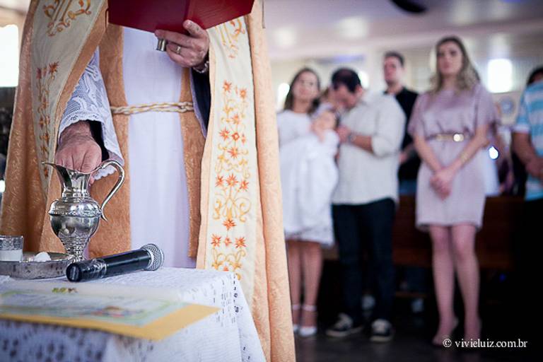 padre abençoando a água batismal
