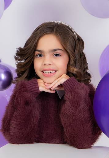 criança com as maos no queixo sorrindo