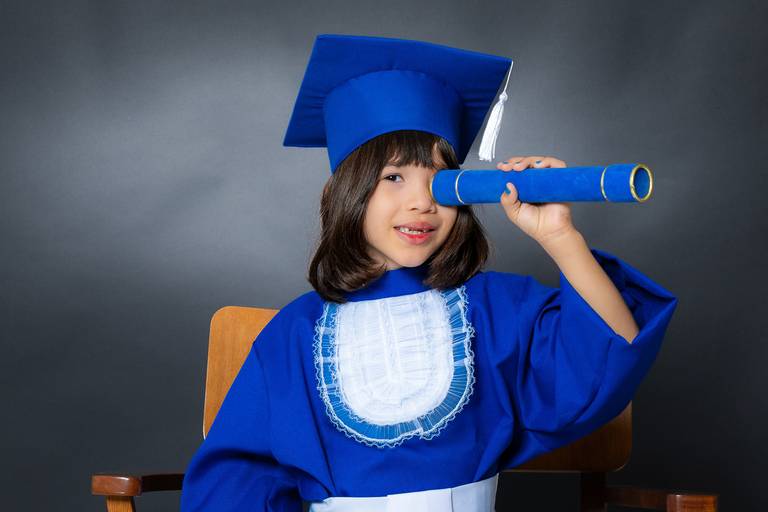 criança na formatura usando o canudo 