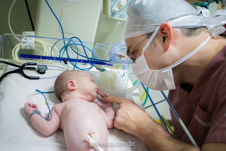 Pai brinacndo com o filho recém nascido