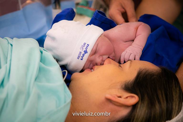 mãe dando um beijo no filho após nascer