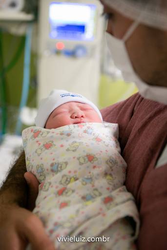 bebê recém nascido no colo do pai