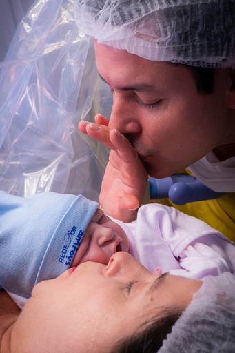 pai dando beijo no filho recém nascido