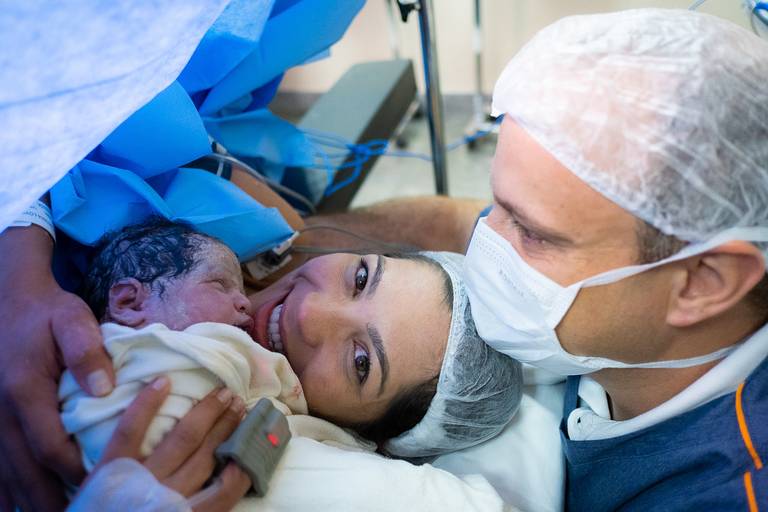 pai, mãe e bebê reunidos após o parto