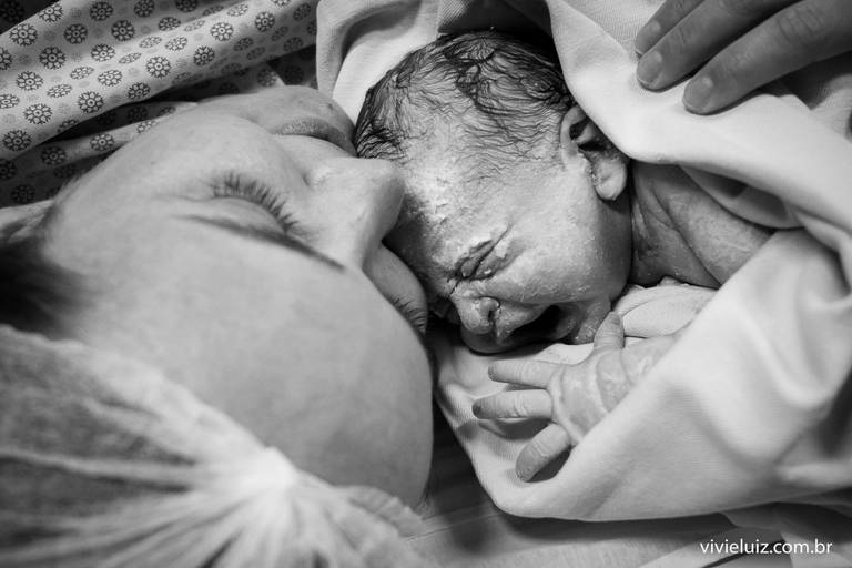 mãe dando um beijo no seu bebê recém nascido