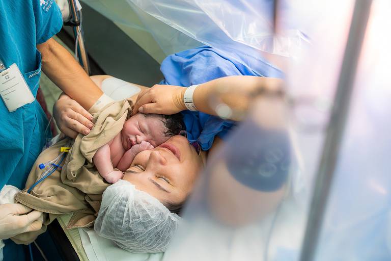 mãe com rostinho colado com o seu filho recém nascido