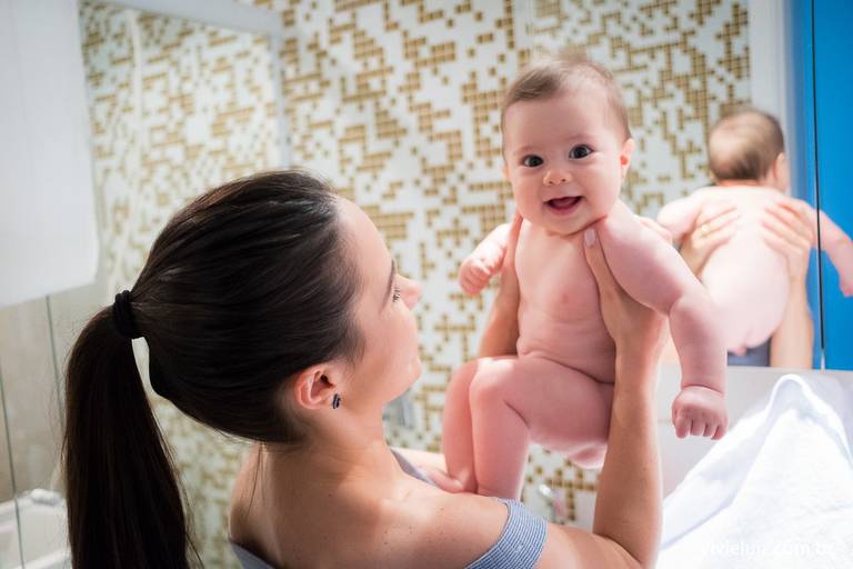mãe segurando o seu filho rindo
