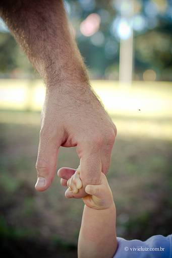 pai segurando a mão do filho