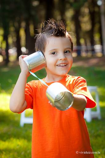 criança briancod com telofene de latinhas
