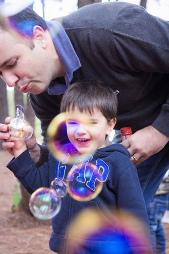 pai e filho brincando com bolhas de sabão