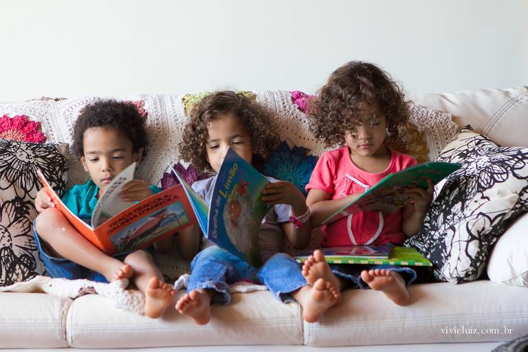 crianças lendo no sofá