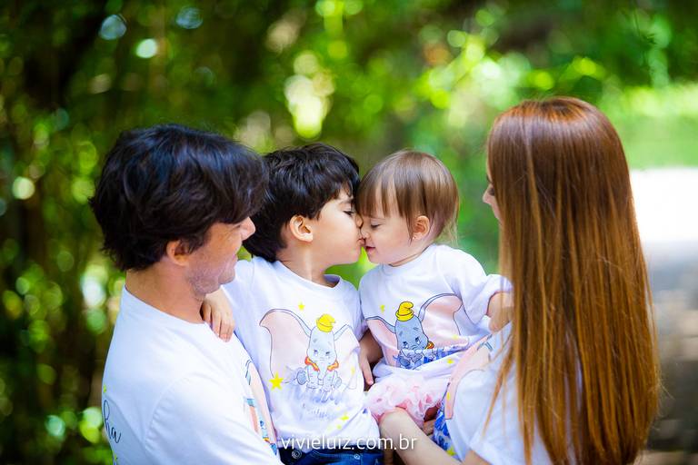 família reunida com o irmãod dando um beijo na irmã