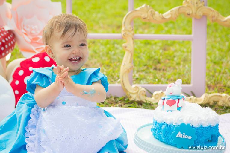 menininha rindo com o seu bolo de aniversário