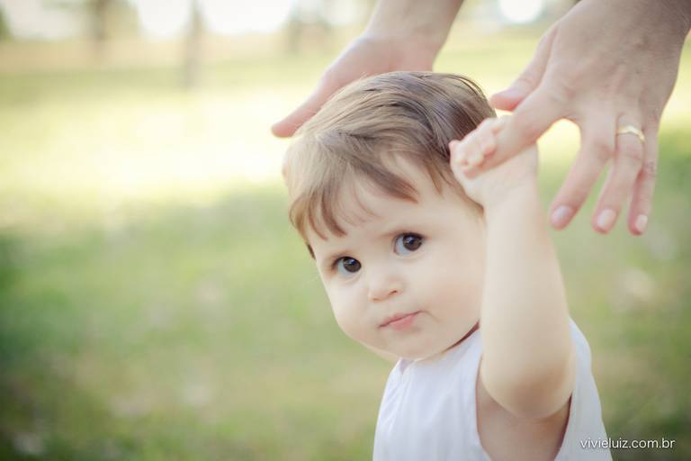 bebê segurando na mão do pai para andar
