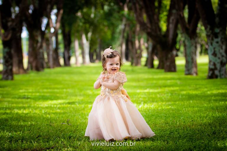 criança sorrindo no meio das árvores