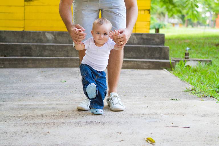 pai ajudando o filho a andar