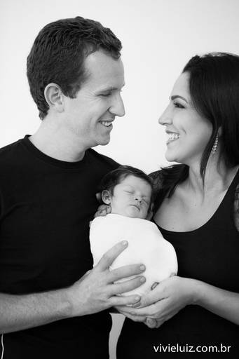 casal  se olhando com a sua filha bebê nos braços