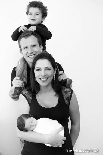 pai carregando o filho no pescoço com a mãe do lado