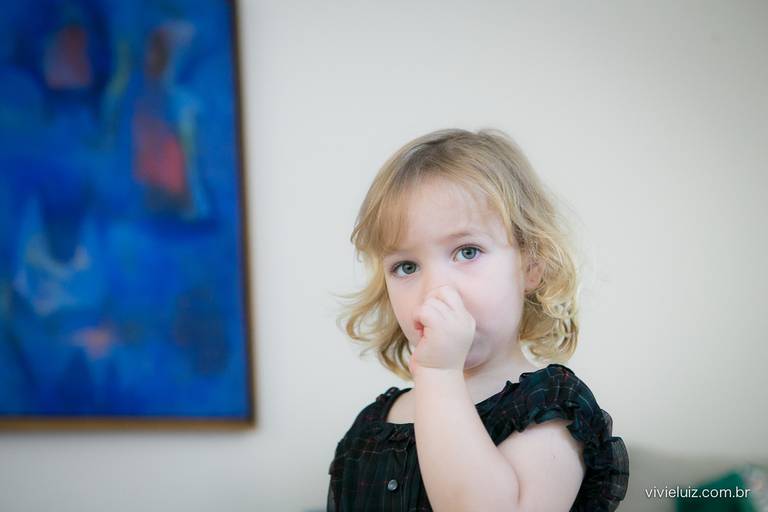 menina criança com o dedo na boca