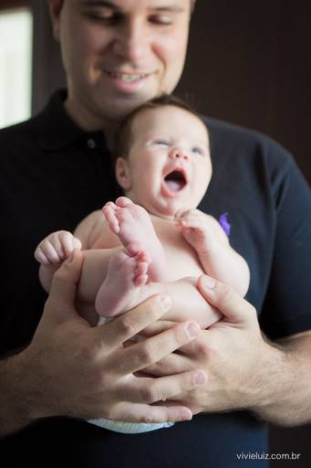 bebê sorrindo no colo do pai