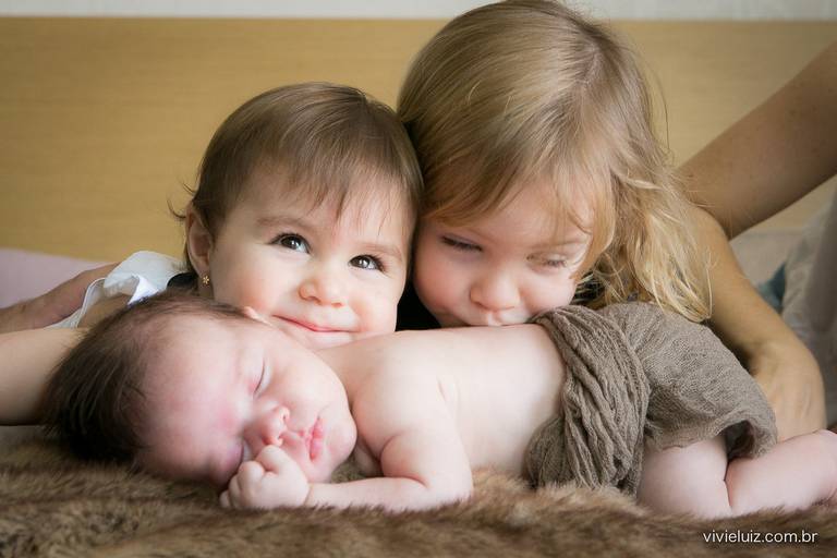 dois irmãos juntos com o mais novo irmãozinho