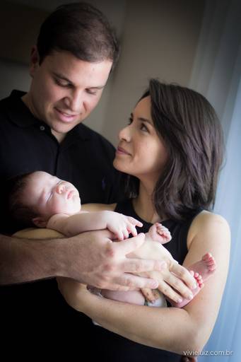 pai olhando para o seu filho bebê no colo da mãe