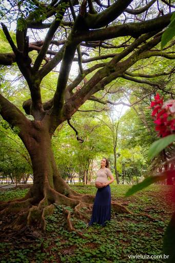 mulher segurando a sua barriga grávida no meio das plantas