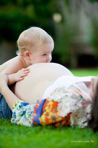bebê dando beijo na barriga grávida da mãe