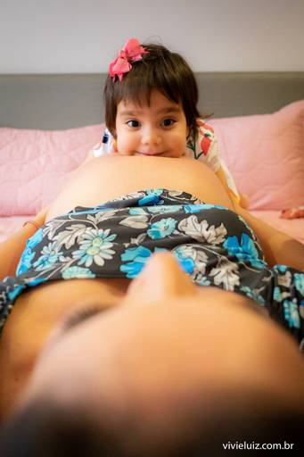 irmão olhando a mãe grávida