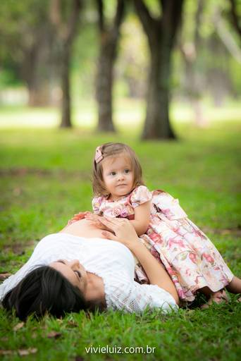 filha olhando a barriga grávida da mãe