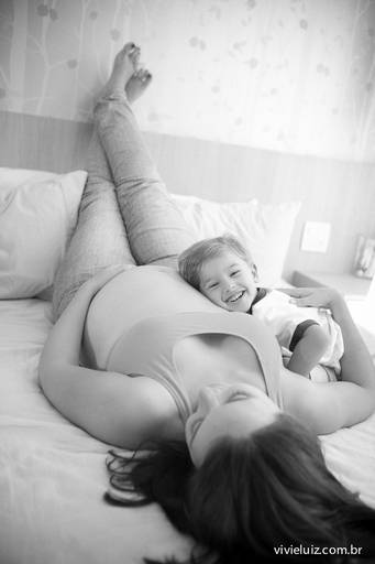 filho abraçado com a sua mãe grávida